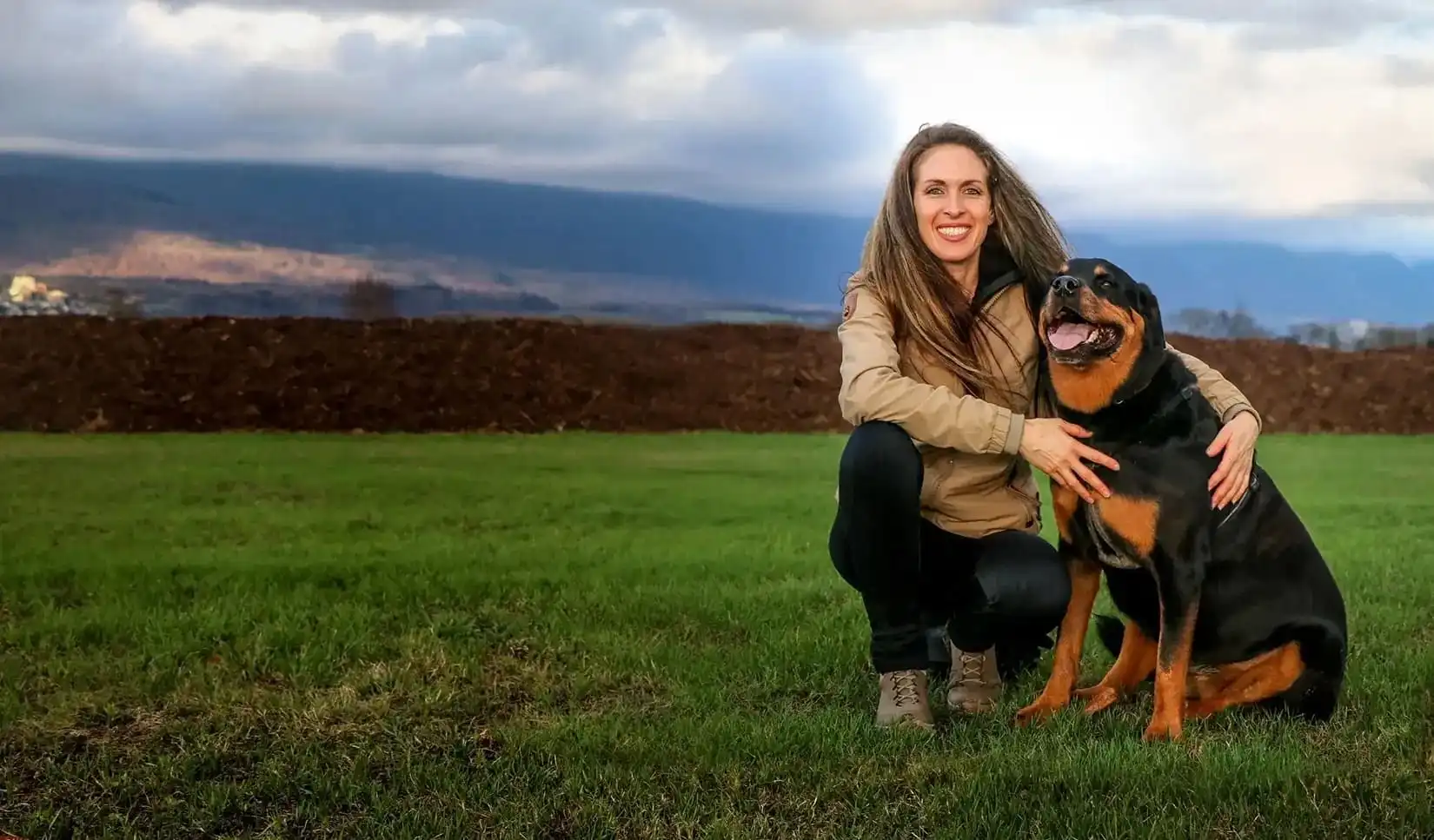 Hundetrainerin Olivia Garz mit ihrem Rottweiler auf einer Wiese – Natural Dog Move, indianische Hundeschule in Bern